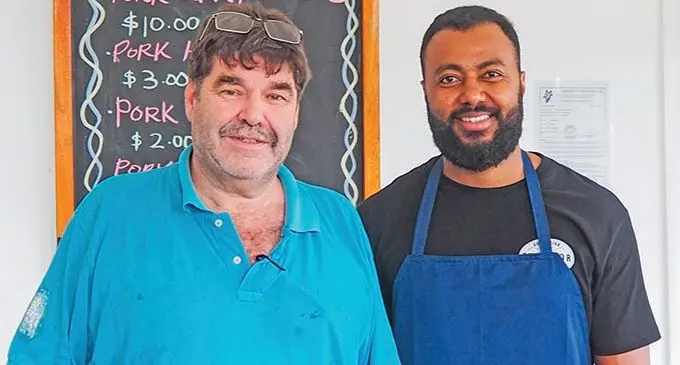The Pork Shop owner Simon Cole and shop manager Apakuku Nalawa, better known as leader of the band INSIDE OUT working at The Pork Shop. 