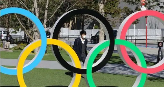 A pedestrian wearing mask walking past the Olympic rings in Tokyo, Japan ON March 12, 2020. (Xinhua/Du Xiaoyi) The delayed Tokyo 2020 Olympic Games will be held from July 23 to August 8, 2021.