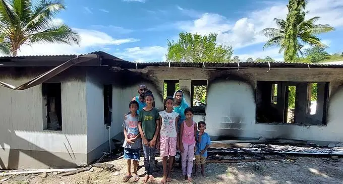 Daniel Muneef and his family in front of their burnt home at Saru, Lautoka on December 21, 2022. Photo: Nicolette Chambers