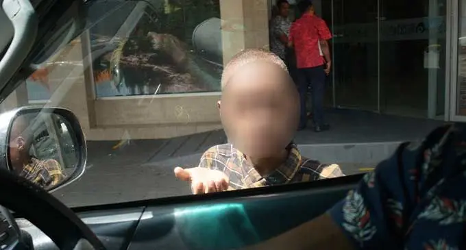 A boy stops a vehicle and begs for money in Suva. Photo: Ronald Kumar