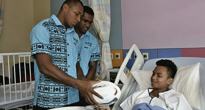 Fiji Airways Fijian 7s captain Paula Dranisinukula presents a signed rugby ball to a patient at KK Women and Childrens Hospital in Singapore on April 9, 2019. Photo: FRU Media