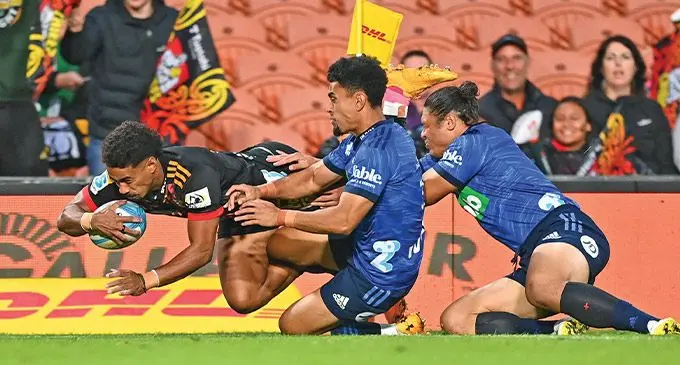 Chiefs winger Emoni Narawa beats Blues full-back Stephen Perofeta and Caleb Clarke to score the first try in the opening 26 seconds at the FMG Stadium Waikato in Hamilton, New Zealand, on April 1, 2023. Photo: Otago Daily Times.