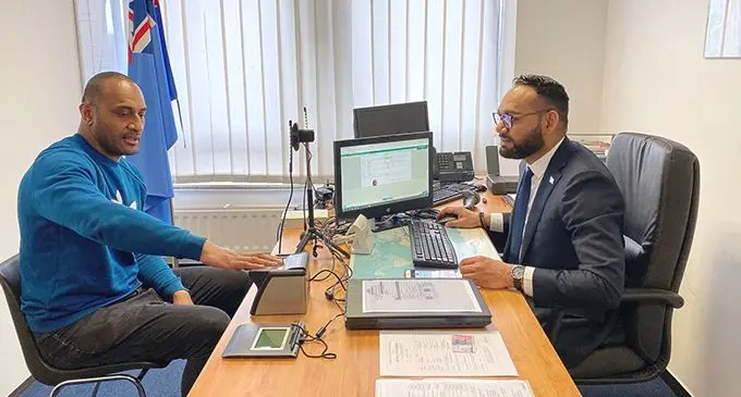 Taniela Gavidi, Second Secretary at Fiji’s Embassy in Brussels assists Joe Rokocoko with the processing of his ePassport.  Photo: DEPTFO News
