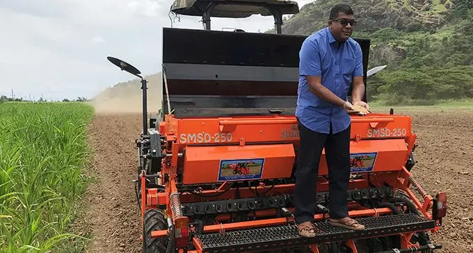 Minister for Agriculture Mahendra Reddy at the back of the rice planting machine showing the seeds at Barara between Nadi and Lautoka on February 5, 2020. Photo: Charles Chambers
