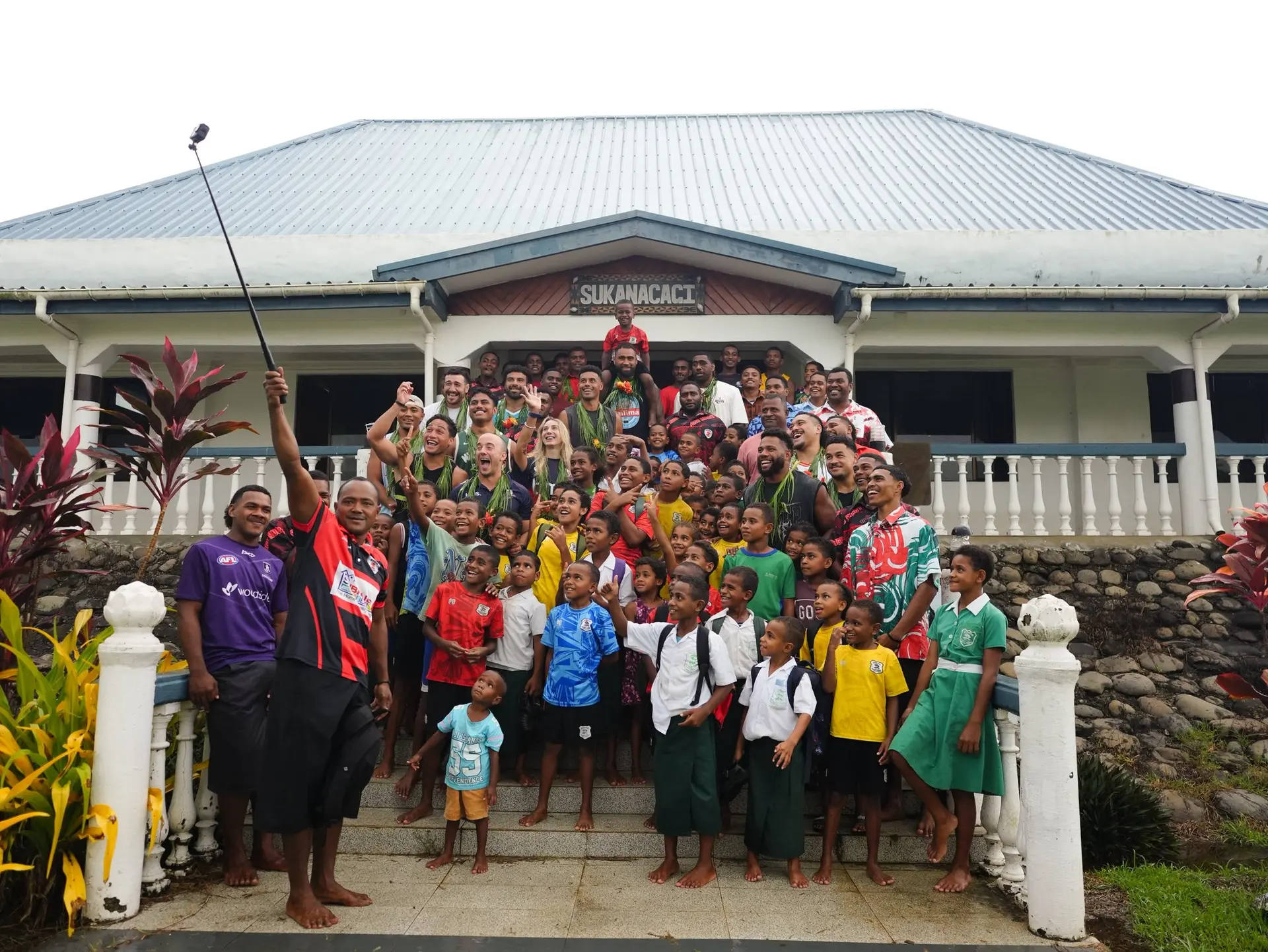 Queensland Reds players, officials and villagers in front of Sukanacagi House in Vitogo, Lautoka.