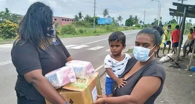 Helping Hands Fiji coordinator Ashley Krishna (left) helps Pooja Prasad and her son Viansh Kumar  on June 10, 2021. 