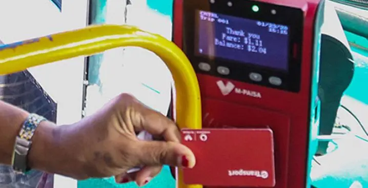 A passenger taps her e-ticketing card while boarding the bus.