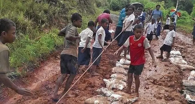 Children help set up traction so that vehicles could travel up or down hill.  