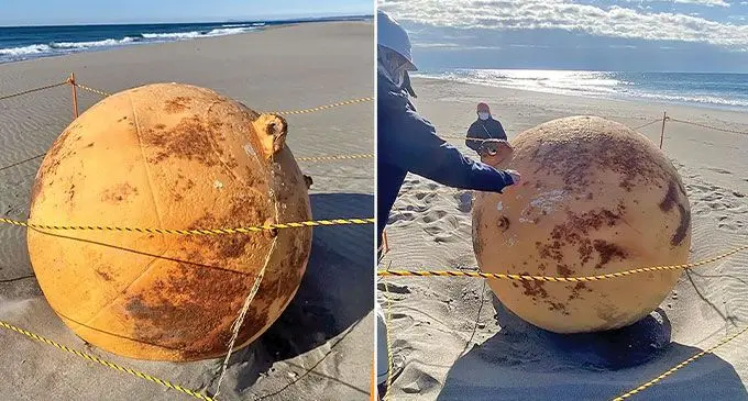 The metal ball being examined on Enshu Beach, Japan