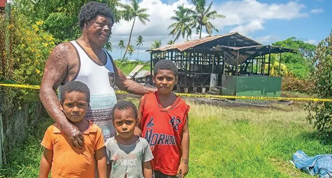 Voreqe Beratabua with his children, Voreqe Beratabua Jr, 8, (fourth from left) Ratu Keveueli Beratabua 7, (left) and Lawrence Beratabua 4, in front of their burnt home at Vatuwaqa in Suva on December 21, 2020.  Photo: Leon Lord 
