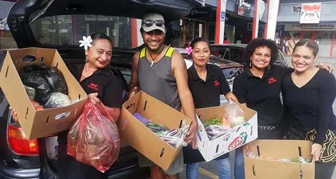 Mataiasi Savou (second from left) delivers fresh vegetables to staff of Bad Dog Cafe in Damodar City in Suva.