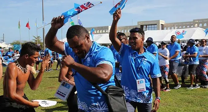 Team Fiji athletes Michael Peters (right) and Penioni Tagituimua of the Fiji Rugby League team celebrate the Pacific Games flag raising ceremony with other Team Fiji athletes and officials on July 6, 2019 with a student of Solosolo Primary School at Falefono, Mulinu’u in Samoa. The Team Fiji contingent, during their stay in Samoa, has been adopted by the students of Solosolo Primary School. The Pacific Games opening ceremony will be held today.  Photo: Anasilini Natoga 