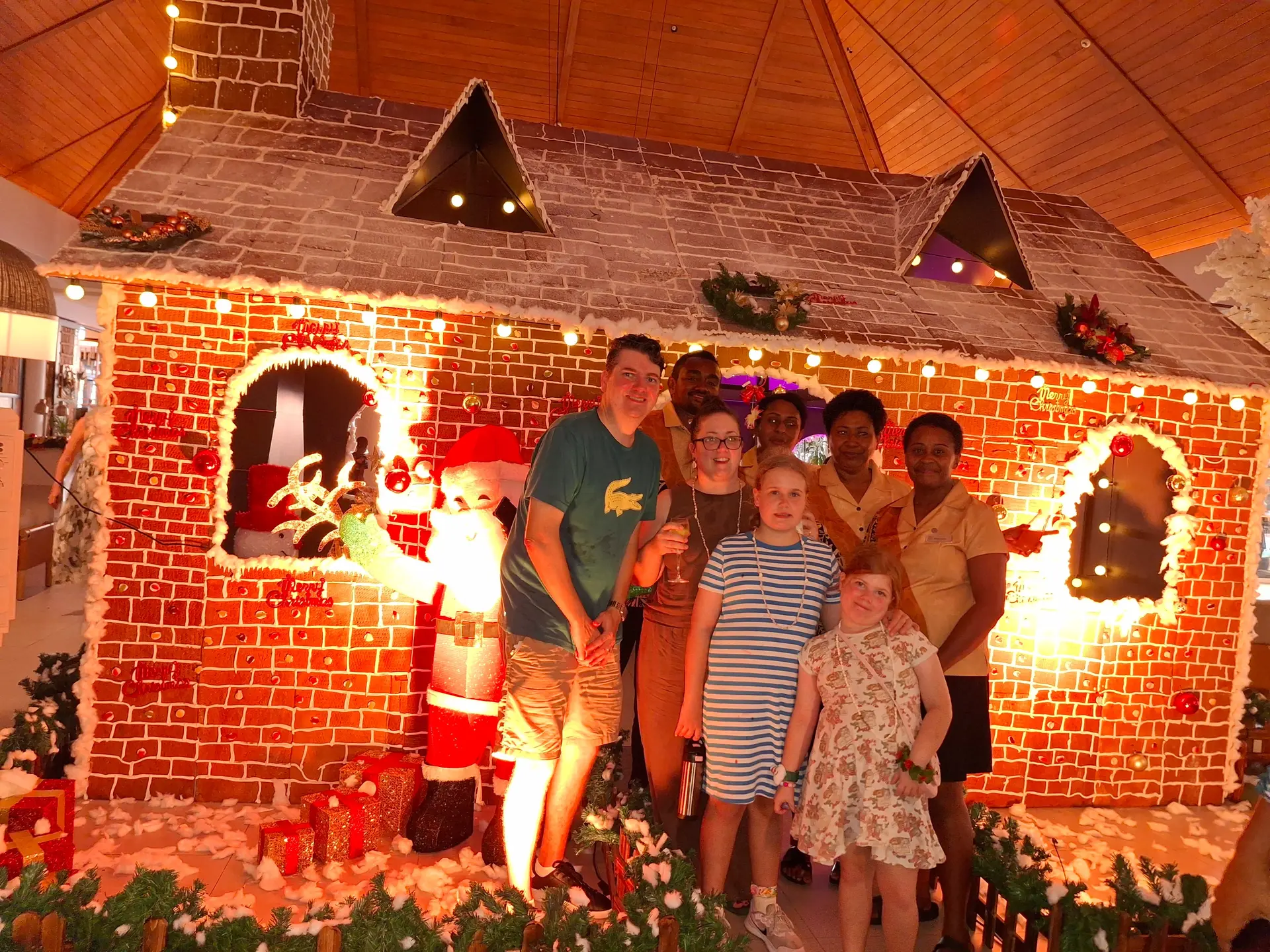 uest and staff at a makeshift Christmas house in the lobby area at Sheraton Fiji Golf and Beach Resort.