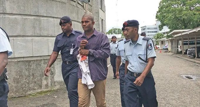 Sailosi Naivalurua (sentre) escorted by a Police officer outside the Suva courthouse on February 12, 2021.   Photo: Ashna Kumar