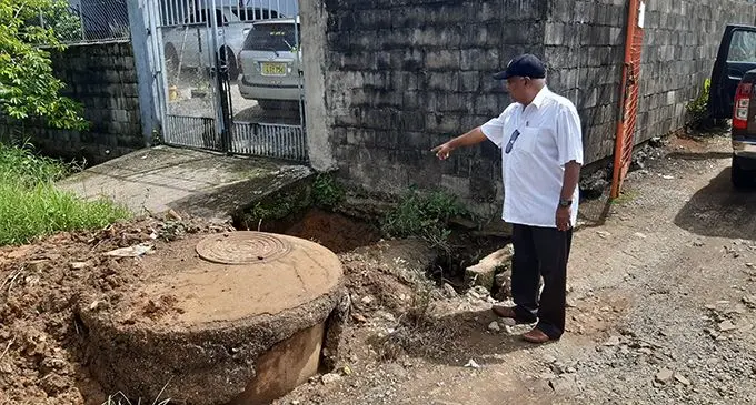 Vijay Nair points to the drain and sewage chamber which is causing a havoc in Kuluvutu Road in Nadera.  Photo: Shalveen Chand