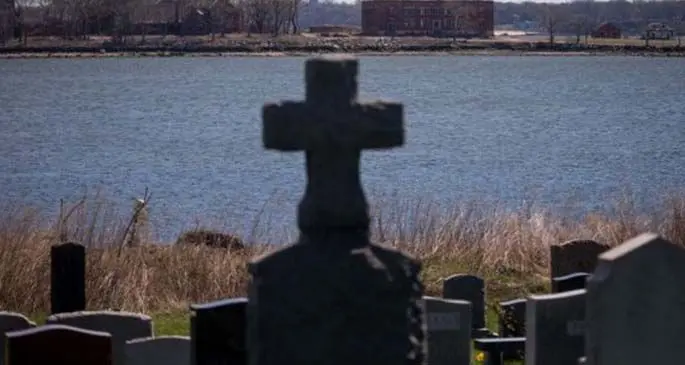 A large burial pit and abandoned buildings are seen on Hart Island where some of the COVID-19 victims are buried, in New York, the United States, April 11, 2020. (Photo by Michael Nagle/Xinhua)