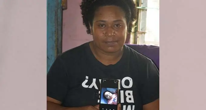 Maria Senijale holding her phone with a picture of baby Joshua Samuela Turagatani. Photo: Laisa Lui
