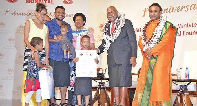 From left Loretta Naviti, daughter Isobel Naviti, husband Waisake Naviti carrying son Isireli David Madrai Naviti, son Apenisa Naviti with Prime Minister Sitiveni Rabuka and wife Sulueti and Global Humanitarian and Founder Sadguru Sri Madhusudan Sai during the Sri Sathya Sai Sanjeevani Children’s Heart Hospital one year anniversary celebration at Civic Centre on April 27, 2023. Photo: DEPTFO News.