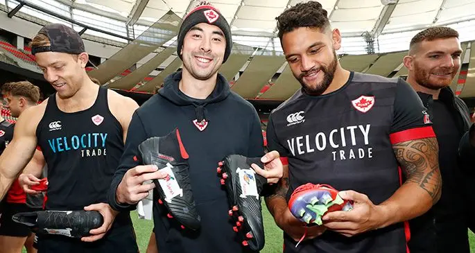 Canada 7s captain Nathan Hirayama (middle) shows his new match boots designed by the children at the Ronald McDonald House BC during training at the BC Place Stadium in Vancouver, Canada on March 4, 2020. Photo: World Rugby. Photo: World Rugby