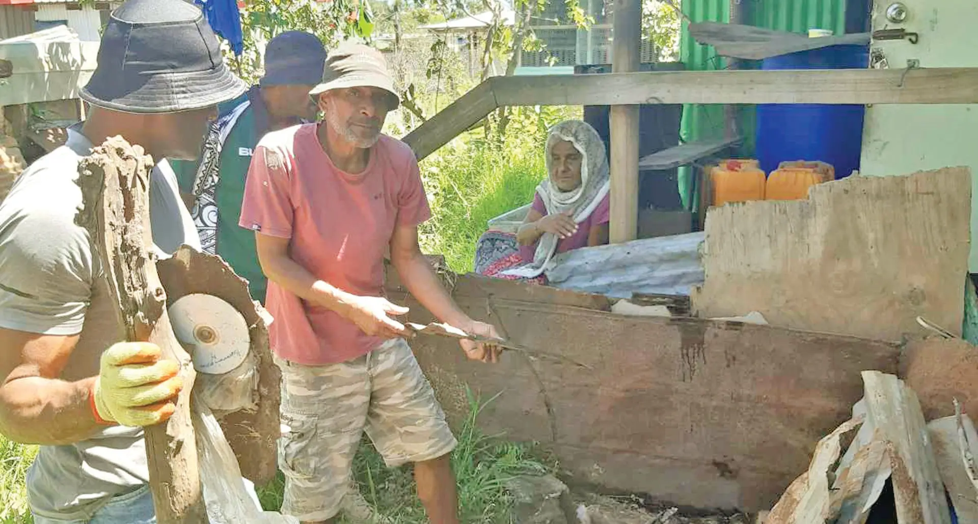 PYGMIES members and volunteers cleaning up the compound as Ram Devi looks on.