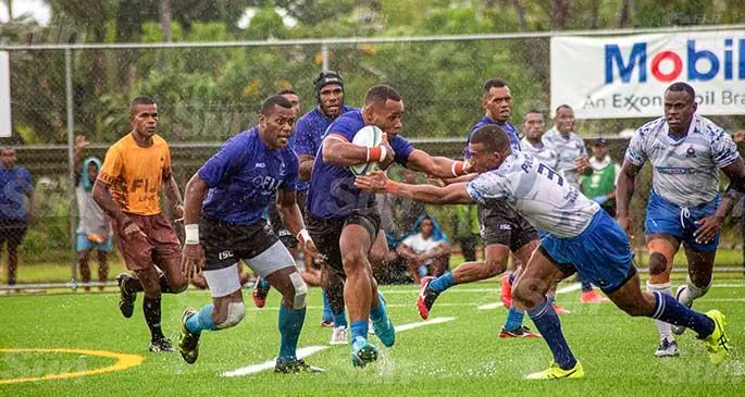 Fijian 7s halfback Livai Ikanikoda fends Suliano Volivoli of Police during the Cup final of the Mobil Uprising Sevens at the Uprising Sports Centre in Pacific Habour, Deuba on February 6. 2021. Providing support for Ikanikoda are forwards Simione Cece and Kavekini Tabu (headgear) as Fiji won 31-0. Ikanikoda was named Player of the Tournament.. Photo: Leon Lord