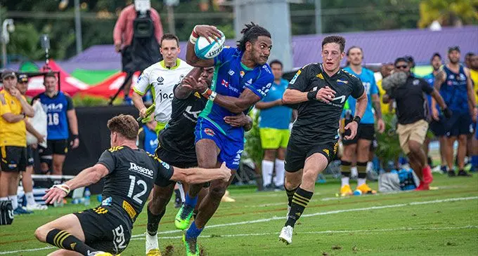 Livewire Swire Shipping Fijian Drua winger Selestino Ravutaumada, is taken in a tackle by Jordie Barrett (12) of the Hurricanes at the HFC Bank Stadium in Suva today. Photo: Leon Lord