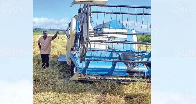 Mahendra Prasad stands beside the rice combine harvester in Wailevu, Labasa on May 19, 2021. Photo: Shratika Naidu