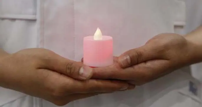 A newly recruited nurse holds a mock candle during a capping ceremony at Peking University People's Hospital in Beijing, capital of China, April 26, 2020. (Xinhua/Zhang Yuwei)