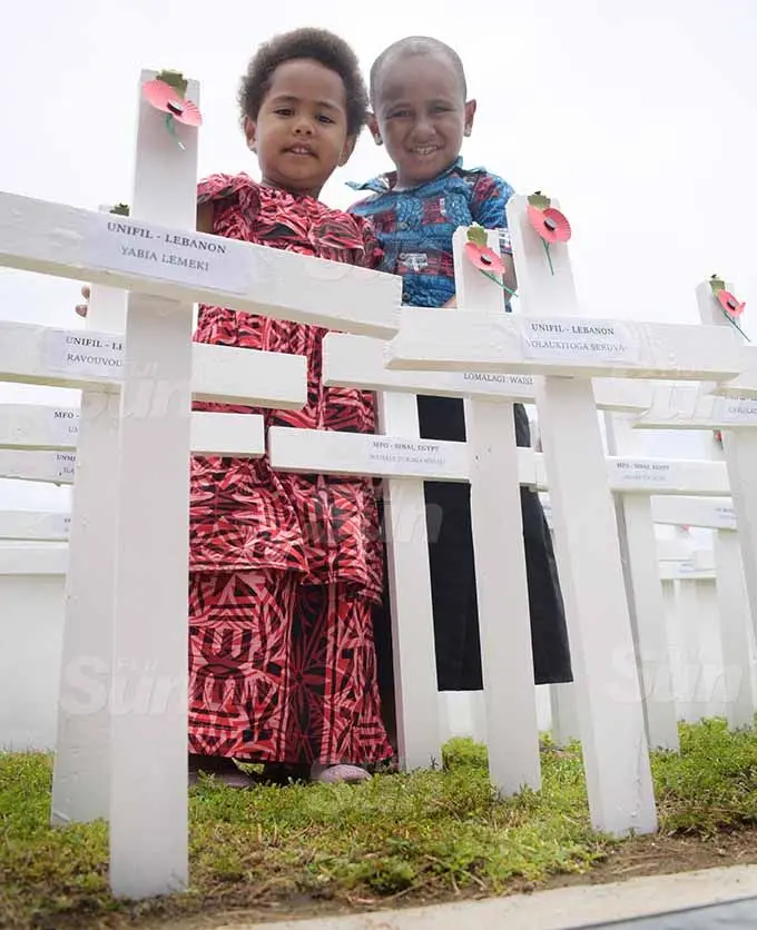 Sala Kotoisuva and Ponijese Kotoisuva next their cross marked for the late grandfather Waisale Turaganivalu , who died while on peace keeping duty in 2011 during Remembrance Day ceremony at National War Memorial ground on November 11, 2020. Photo: Ronald Kumar.
