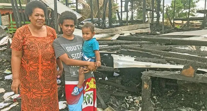 Luisa Leleiwaqa with her grandchildren Emali Yalati and Ratu Isikeli Lalai Ledua in front of what’s left of their home in Naseakula,  Labasa, on September 20, 2021. Photo: Shratika Naidu  
