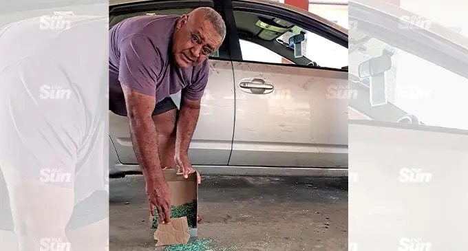Taxi Driver, Peni Moceidreke clearing up the pieces of glass after his taxi was broken into on November 2, 2021. Photo: Nicolette Chambers