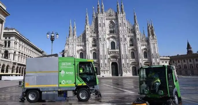 Sanitation workers clean the ground at Piazza del Duomo in Milan, Italy, on March 31, 2020.(Photo by Daniele Mascolo/Xinhua)
