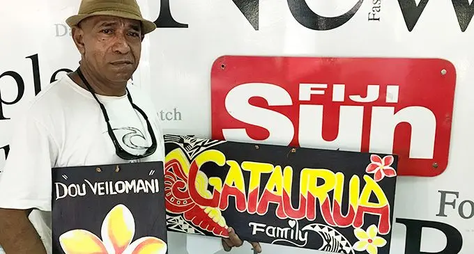 Olita Kau Waradi with two of his colourful wall hangings.  Photo: Charles Chambers