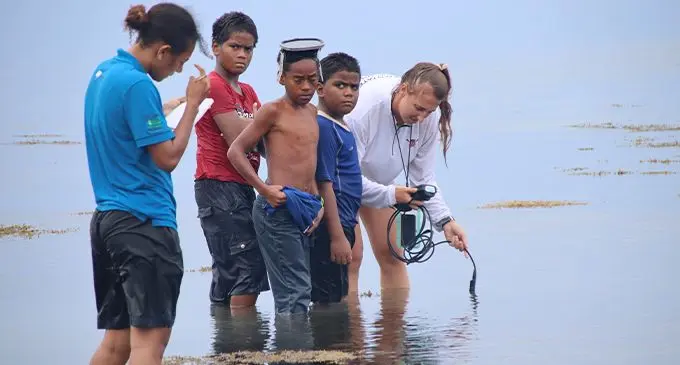Seagrass researcher Carrie Wentzel with Marine Scientist Susana Tauyavuca being assisted by a few children of Waiqori village, Oneata on March 19, 2022. Photo: Kelera Sovasiga