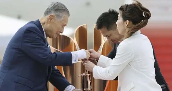 Olympic gold medalists Tadahiro Nomura (C) and Saori Yoshida (R) hand over the flame to President of Tokyo Organizing Committee of the Olympic and Paralympic Games (Tokyo 2020) Yoshiro Mori during the Olympic flame arrival ceremony in Miyagi of Japan, on March 20, 2020. (Kyodo News/Handout via Xinhua)