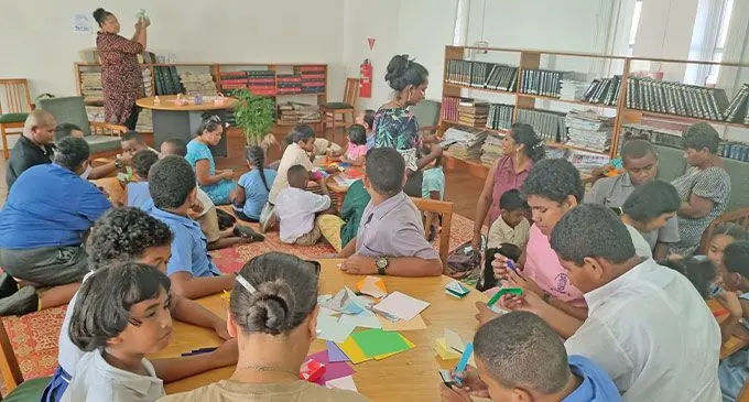 Student with their parents making Easter baskets using origami papers at the Suva City Carnergie Library. Photo: Laiseana Nasiga 
