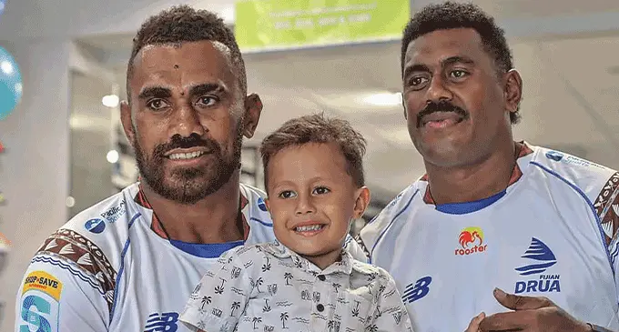 Swire Shipping Fijian Drua winger Eroni Sau (left) and Kalione Nasoko (right) with a fan at the Jacks of Fiji store, Lautoka on April 26, 2023. Photo: Fijian Drua Media