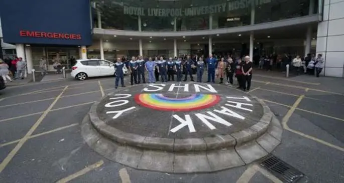 National Health Service (NHS) staff members gather outside the Royal Liverpool University Hospital for the weekly "Clap for Our Carers" campaign in Liverpool, Britain on April 23, 2020. (Photo by Jon Super/Xinhua)
