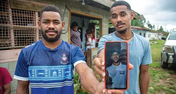 Brothers Tevita Saukuru (left) and Simione Dusilele, with a photo of their late brother, Marika Lagilolo, at their home in Korobebe Village, Sabeto, Nadi. Photo: Leon Lord