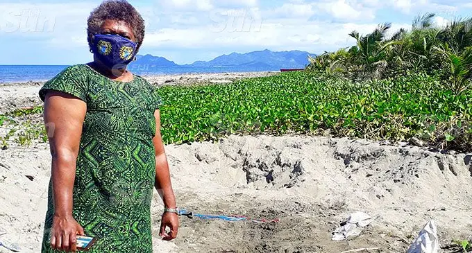 Director of Lands Irena Nayacalevu shows the sinkholes caused by illegal sand extraction at Naitonitoni beach in Navua. INSET: The public notice from the director of Lands. Photo: Ronald Kumar