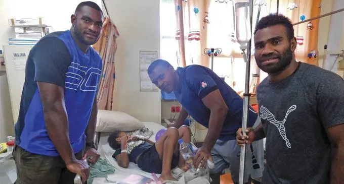 Fiji Airways Fijian 7s reps Mesulame Kunavula, Josua Vakurinabili and Jerry Tuwai attend to a young patient at the Children’s Ward of the Colonial War Memorial  Hospital in Suva on May 2, 2019. Photo:FRU Media