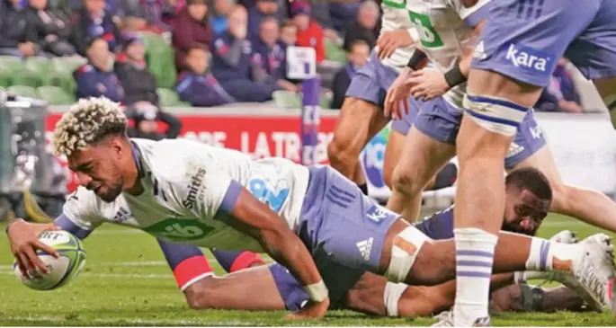 Blues No.8 Hoskins Sotutu dives over Marika Koroibete to score the first of his two tries against Rebels in Melbourne on May 16, 2021. Blues won 50-3. Photo: Blues
