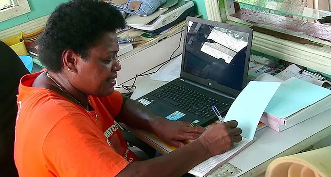 Ms. Baleisuva handling administrative matters in her farm at Sauniwaqa, Nakasi.