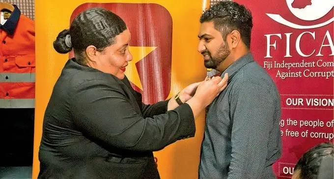 Fiji Independent Commission Against Corruption Manager Corruption Prevention Kolora Naliva badges an employee of Ranjit Garment as part of their ‘I Don’t Accept Bribes’ campaign.