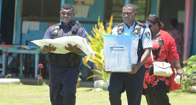 Police officers carry the ballot box following the pre-polling venue closure at Nukui Village in Rewa on December 6, 2022. Photo: Ronald Kumar