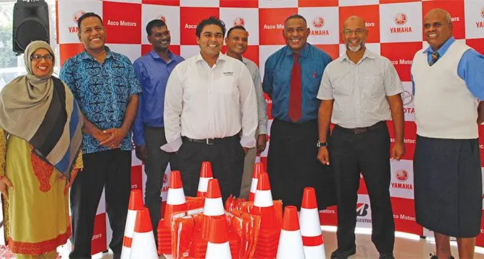 Asco Motors chief executive officer Craig Sims (centre) along with representatives from local primary schools on May 13, 2019. Photo: Sydnee Gonzalez