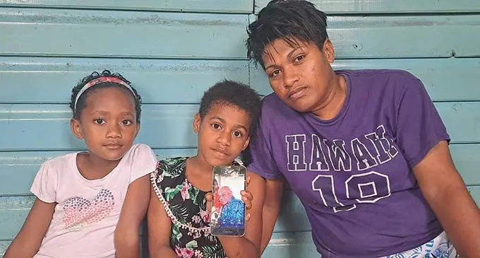 Maloni Nadoi’s adopted daughter Kristina Tutugalala (right) with Mr Nadoi’s granddaughters Litiana Rawei, Losena Narogo at their residence at Sabeto Village, Nadi as they show a photo of the late Mr Nadoi. Photo: Waisea Nasokia