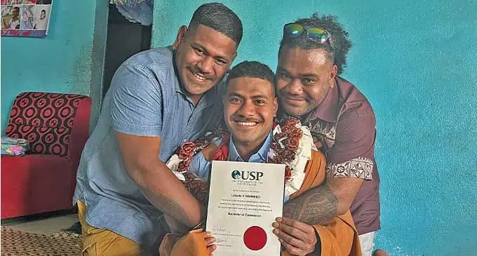 Proud brothers Kelekolio and John Tominiko hug their younger brother Lafaele Tominiko (middle) at their home in Tamavua Village after he graduated from the University of the South Pacific on September 5, 2024. Photo: Wati Talebula-Nuku