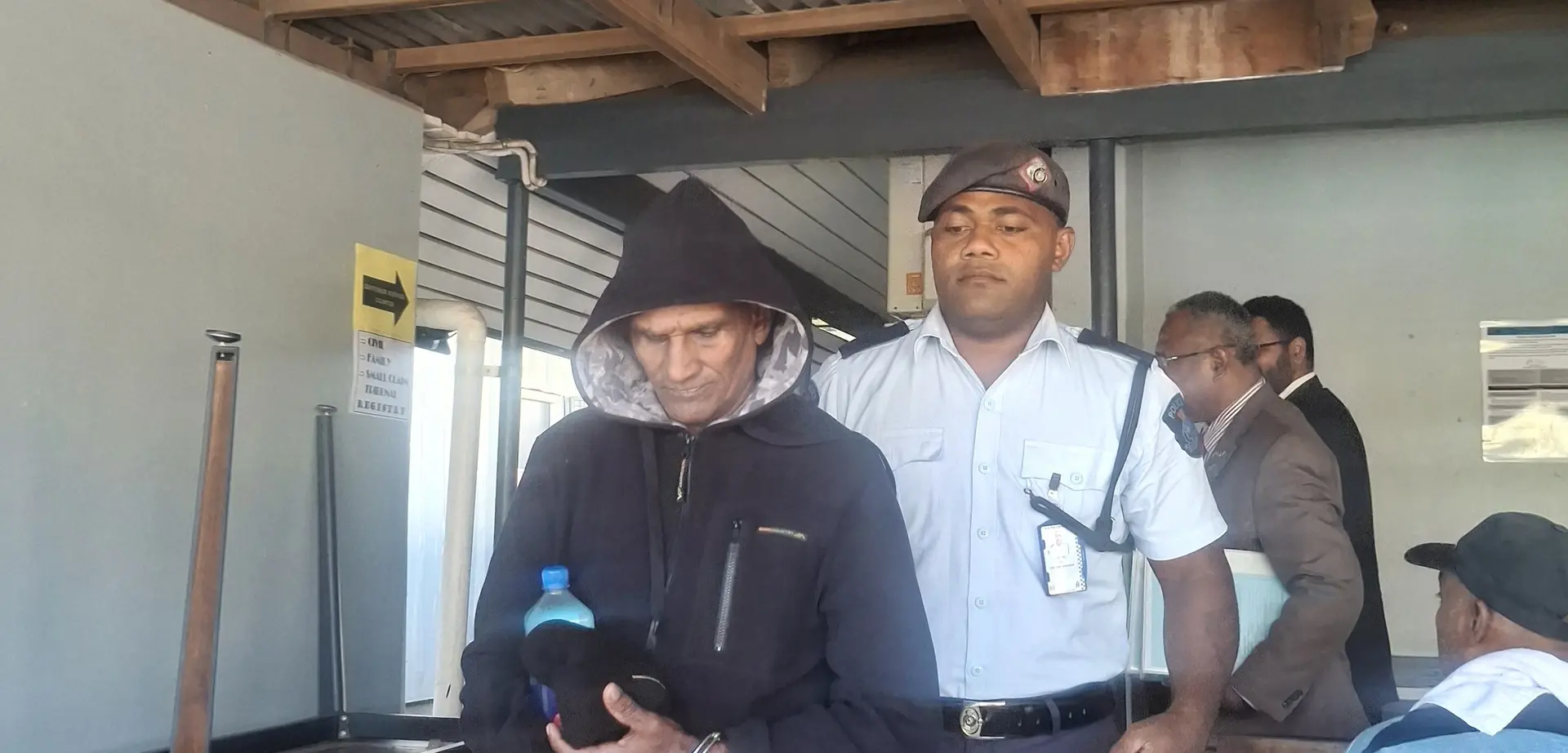 Vishwa Nandan is being escorted by a police officer.