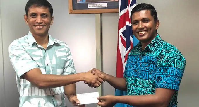 The Permanent Secretary for Industry, Trade and Tourism Shaheen Ali receiving the cheque from Fijian Competition and Consumer Commission chief executive officer Joel Abraham.  Photo: Fijian Competition and Consumer Commission